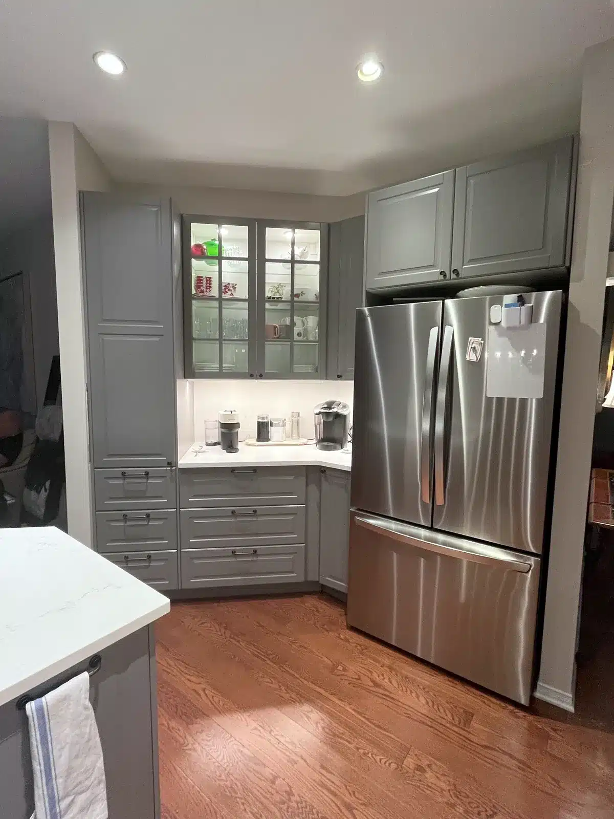 IKEA BODBYN grey glass-door wall cabinets above a coffee station, next to the fridge