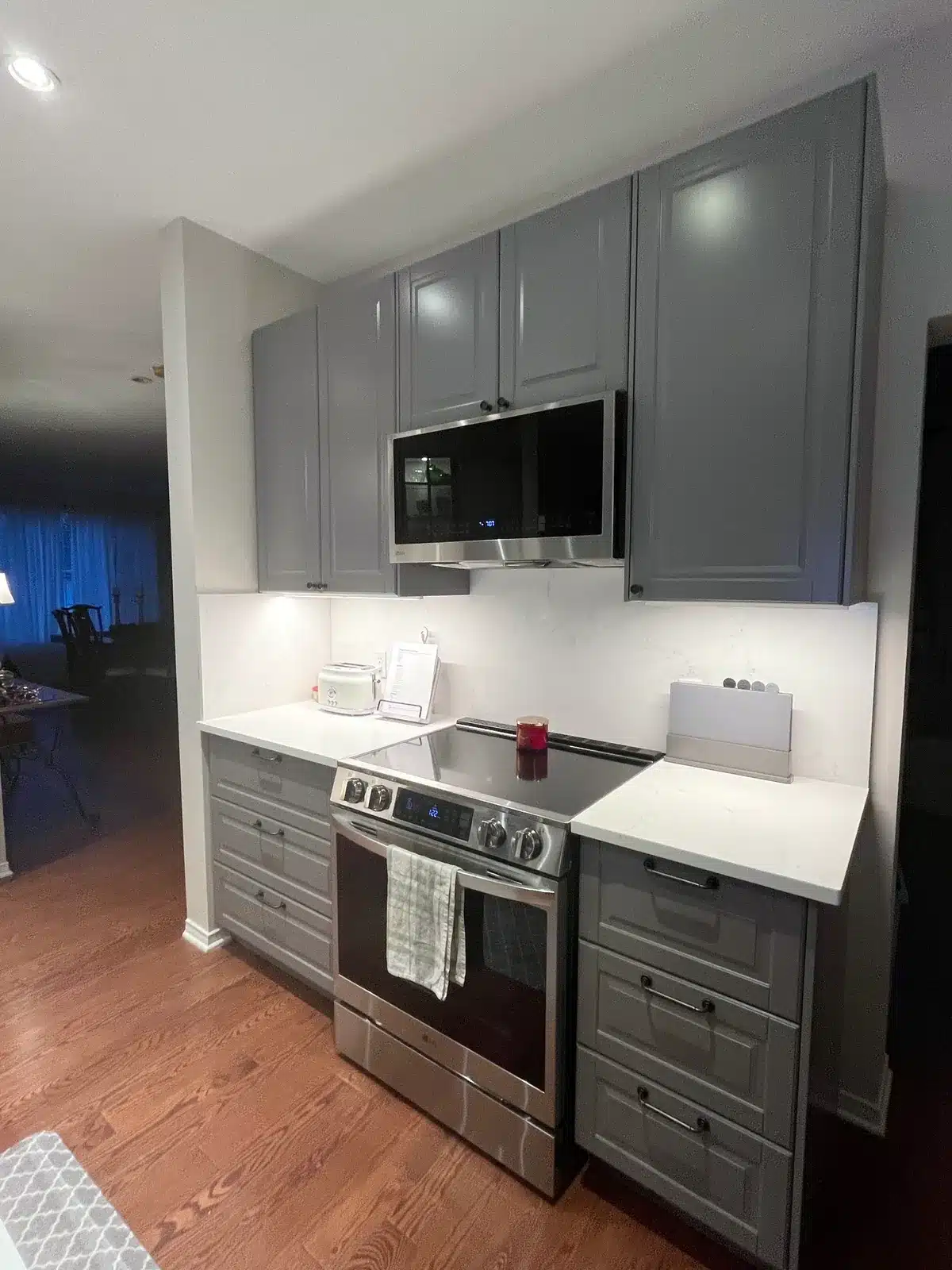IKEA BODBYN grey kitchen with an over-range microwave and under-cabinet lighting