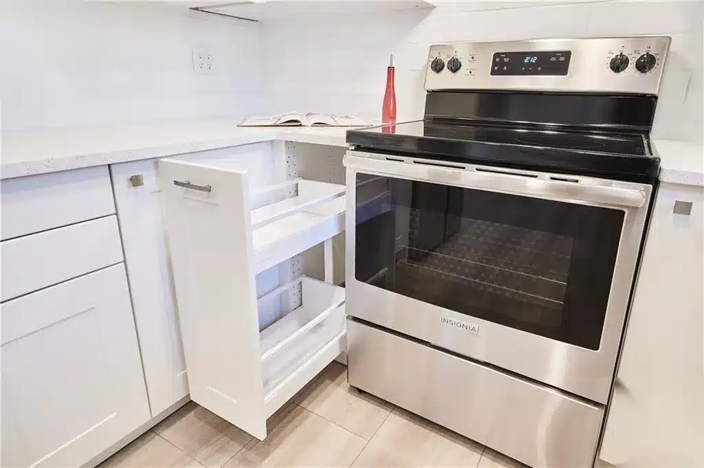 Narrow IKEA AXSTAD matt white pull-out cabinet open next to the range