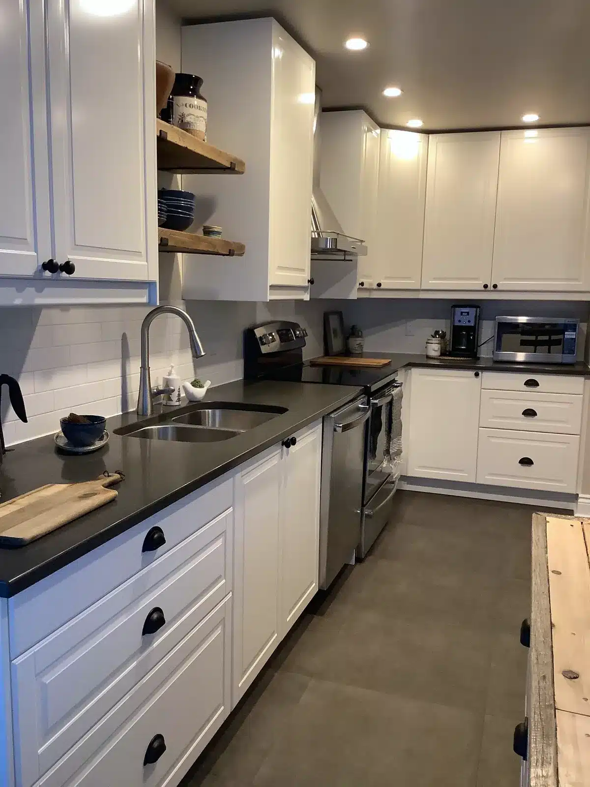 IKEA BODBYN off-white kitchen with dark counters, cup pulls and wood open shelves