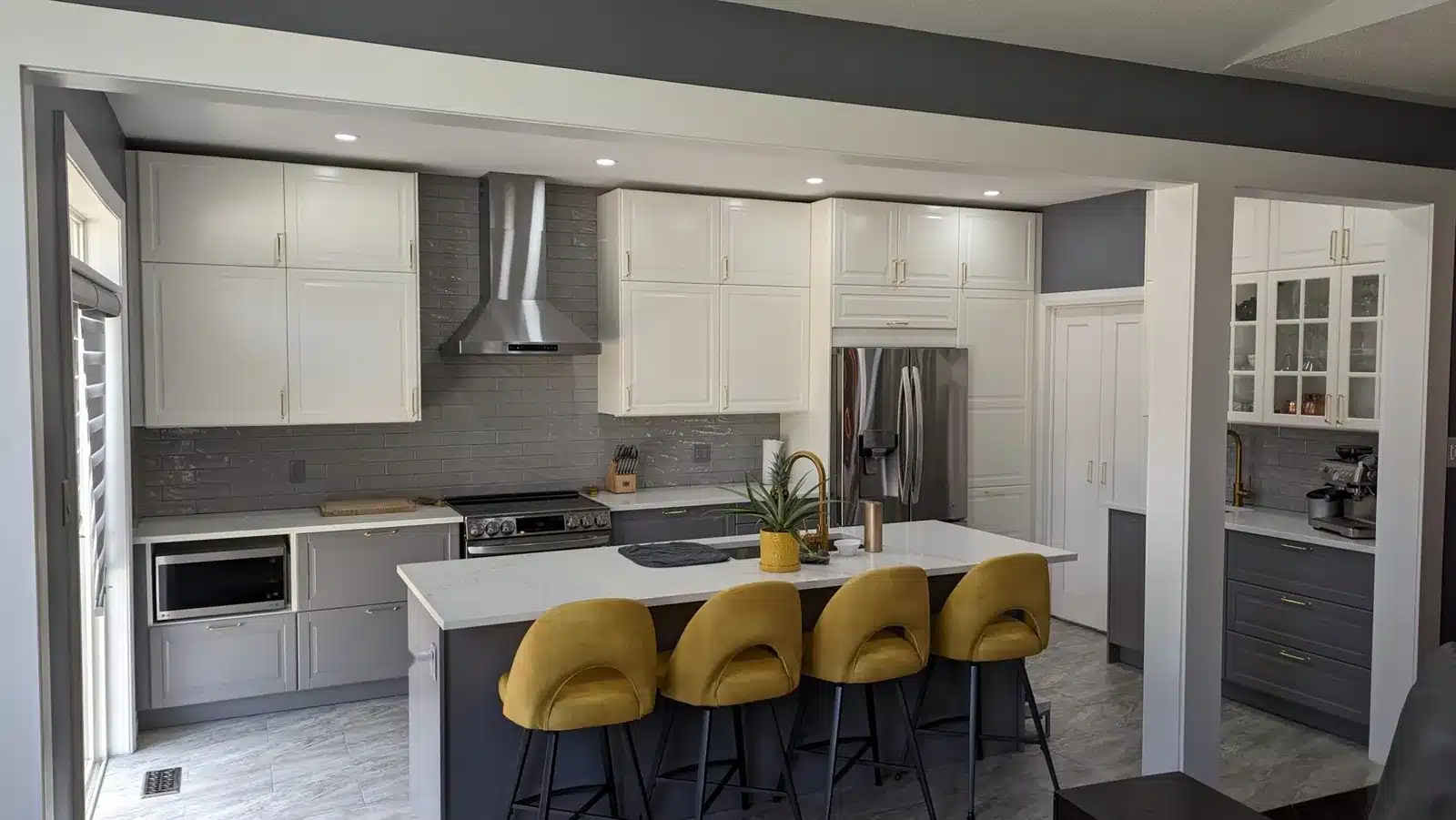 IKEA BODBYN kitchen with off-white wall cabinets, grey base cabinets and a quartz island with four stools