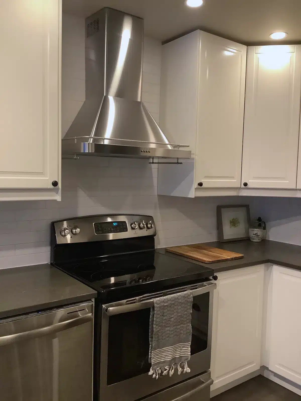 Stainless chimney hood between IKEA BODBYN off-white wall cabinets