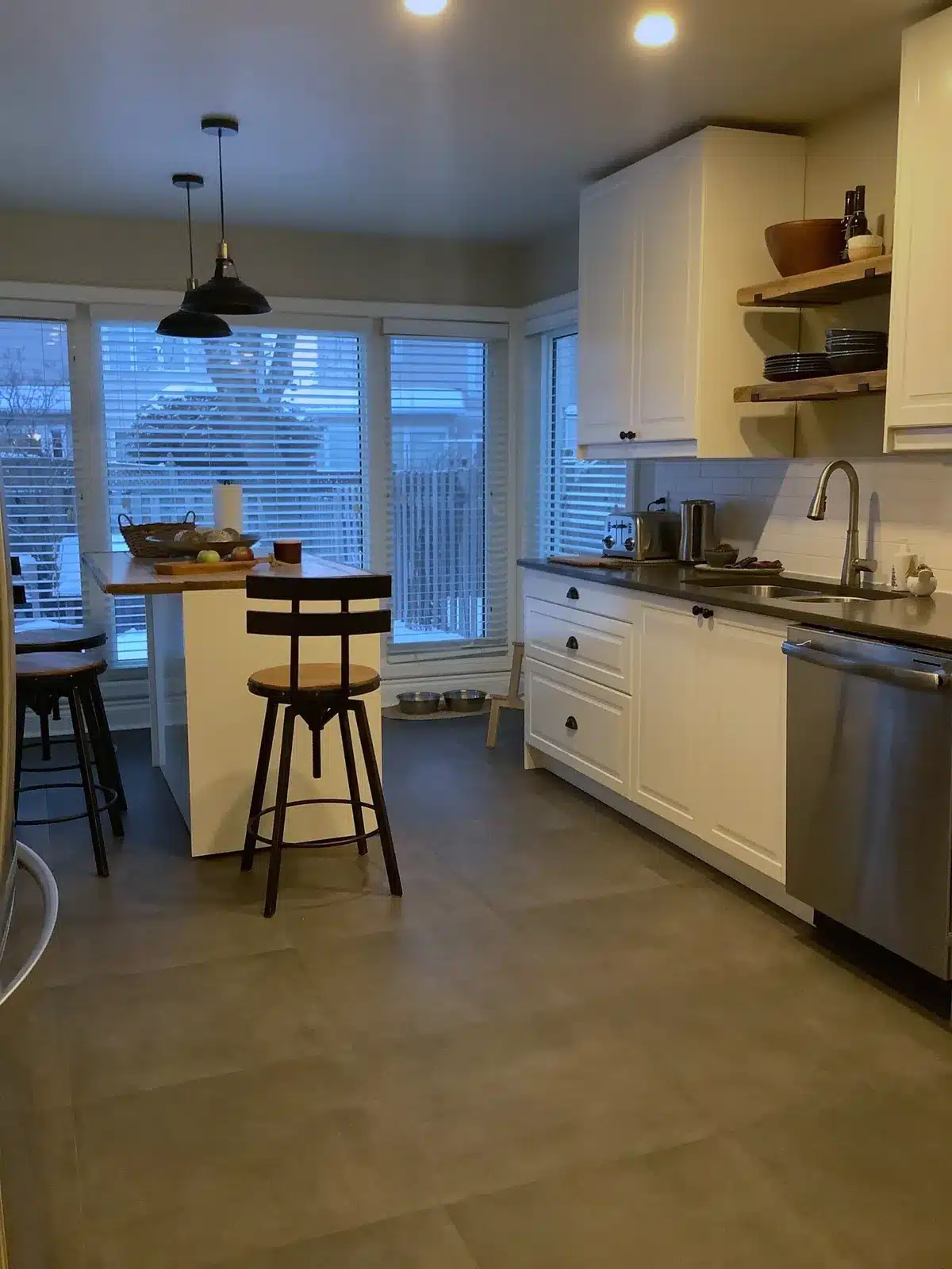 IKEA BODBYN off-white kitchen with dark counters and a small island by the windows